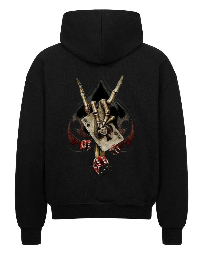 Back view of a black hoodie featuring a bold biker-themed backprint with a skeletal hand throwing the horns, playing cards, dice, and spade symbol – worn by rebellious streetwear fans.

